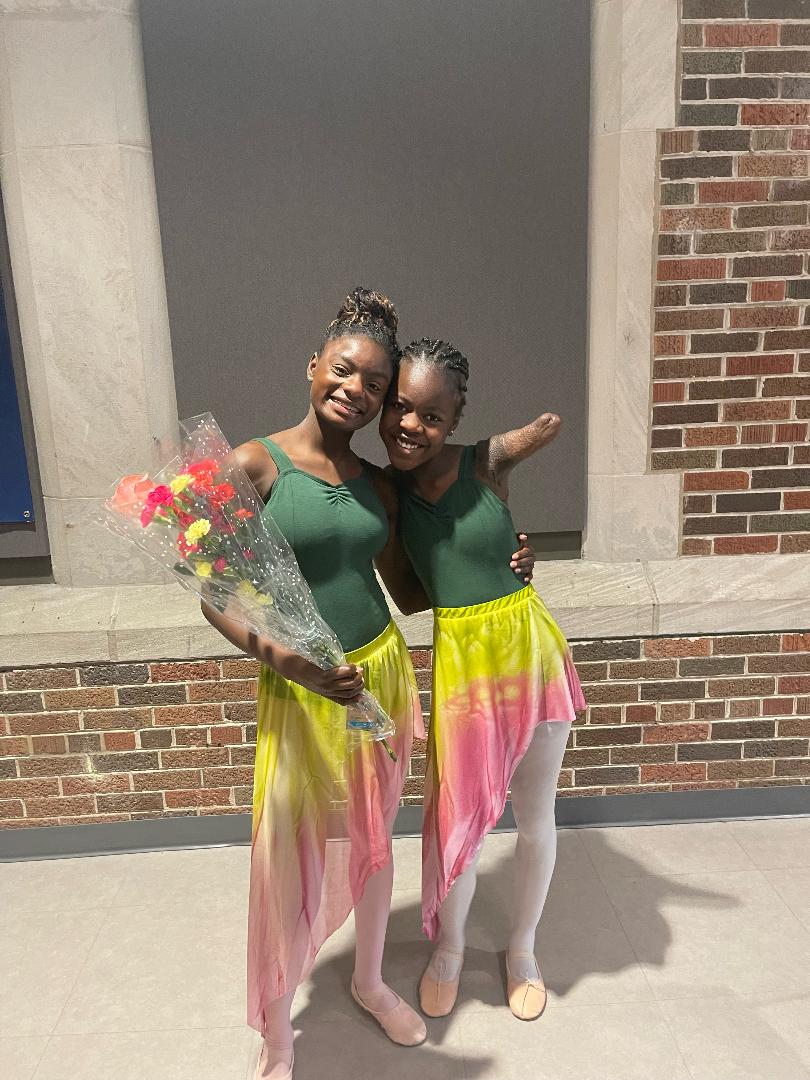 Two Ballet Students Posing With Flowers
